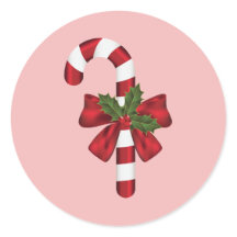 ピンクの背景にリボンとクリスマスホーリーが飾られたキャンディケイン
