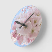 ピンクの花々青い空。 ラウンド壁時計 (傾斜)