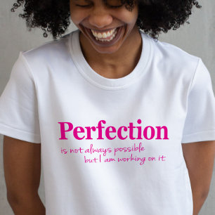 ピンクのTシャツをスローガンに取り組む完璧さ Tシャツ