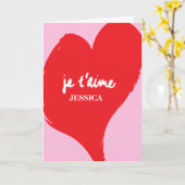 ピンク色の背景にje'aime-文字を持つ赤いハート カード (黄色い花)