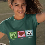 ピースラブサッカー Tシャツ<br><div class="desc">サッカーのママでもサッカーのプロでも、この女子カッコいいのサッカーシャツが大好きだ。平和の愛飾緑の平和のサインとハートと熱心なファンやサッカー選手のためのサッカー素晴らしボール。今すぐサッカーコーチにクリスマスプレゼントを注文！</div>