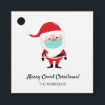 フェイスマメリースクを着たCovid Christmas Santa Claus フェイバータグ<br><div class="desc">おもしろいのクリスマスラベルは、フェイスマスクを着たサンタクロースをフィーチャー。パーソナライズするカスタム文字を追加する。</div>
