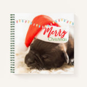 フェスティバルのパグでレッドサンタハットとクリスマスライト ノートブック (正面)