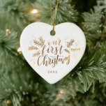 フォトバック結婚した金ゴールド付き最初のクリスマス セラミックオーナメント<br><div class="desc">冬のスペッグと松にアクセントを添えた「私たちの初めてのクリスマス」と言う私たちの手のレタリングをフィーチャー。金ゴールドフォイルフェイクで。</div>