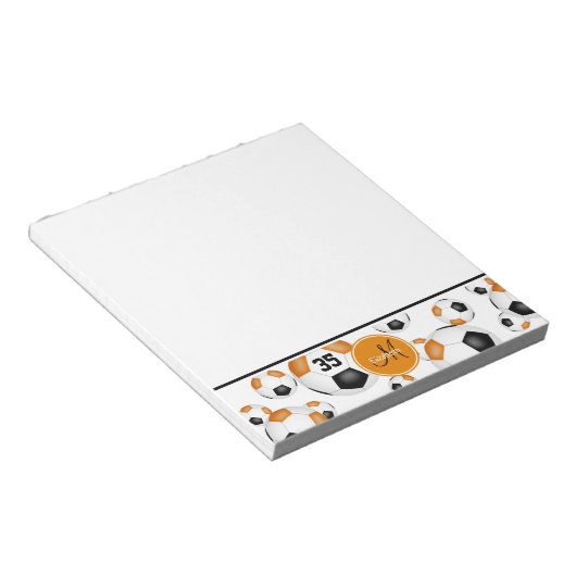 ブラックオレンジ色のサッカーボールのパターン ノートパッド (アングル)