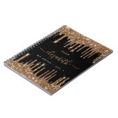 ブラックゴールドのグリッターがモノグラムの名前を滴らせる ノートブック (左側)