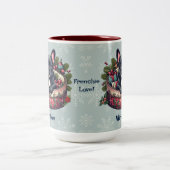 ブラックフレンチー、ホリデーベッド、スノーフレークの背景 ツートーンマグカップ (中央)