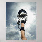 ヘルメットを空中に保持しているサッカー選手 ポスター (正面)