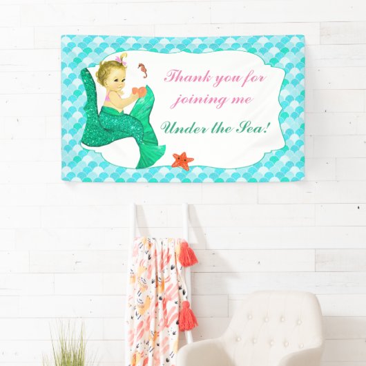 ベビーの人魚はピンクのティール(緑がかった色)の旗の後につきます 横断幕 (インサイチュ)