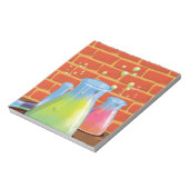 ベンチに置かれた漫画のガラス科学機器 ノートパッド (回転)