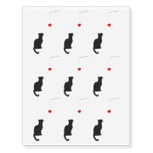 ペンダントハートを見つめる黒猫