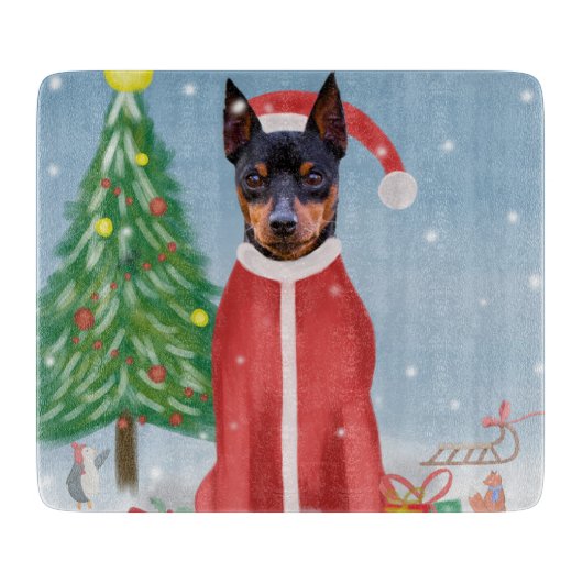 ミニチュア・ピンシュの雪にクリスマスのプレゼントを贈る犬 カッティングボード (正面)