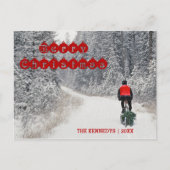 メリークリスマス – バイクもしくは自転車に乗る人が木を持ち帰る シーズンポストカード (正面)