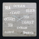 モダンなビーチの流木の海の手書きの原稿 スクエア壁時計<br><div class="desc">流木の背景および海の海が付いているモダンな夏の海のビーチの時計は、手書きの原稿を浜に引き上げます。</div>