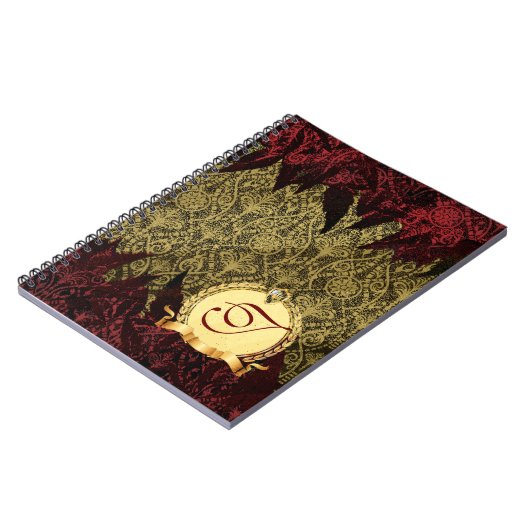 モノグラムとのファンシーでグランジなダマスク織の金ゴールドそして赤 ノートブック (左側)