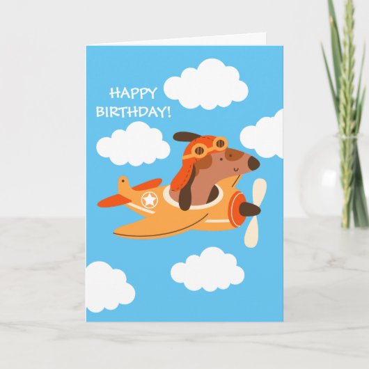 ユーモアたっぷりの犬のパイロットが飛行機を操縦する少年誕生日 カード (正面)