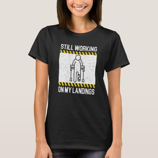 ランディングにまだ慣れてません 骨折 足のケガ Tシャツ (正面)