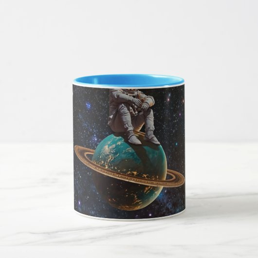 リングのある惑星の銀河に座る宇宙飛行士のデザインのコーヒーマグM マグカップ (中央)