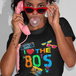 レトロI Love The 80s | 80年代 Tシャツ<br><div class="desc">明るいネオン色の文字ことわざ「私は80年代を愛する」を搭載したおもしろいとカラフル80のブラックtシャツ、カセットテープ、明るいレトロなサングラス、ゲットブラスター（ブームボックス）と散在する星。</div>