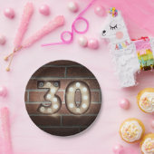 レンガの壁に設置された30歳の誕生日用マーキーのサイン ペーパープレート (パーティー)