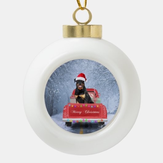 ロットワイラーの犬が雪の中でクリスマストラックに座って セラミックボールオーナメント (正面)