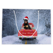 ロットワイラーの犬が雪の中でクリスマストラックに座って ラージペーパーバッグ (裏面)