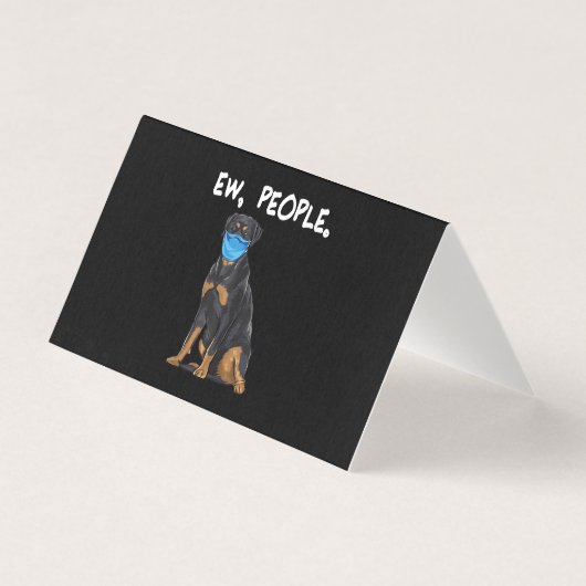 ロットワイラー犬が顔にマスクをつけて人々の間を歩く (正面)