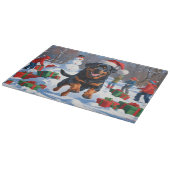 ロットワイラー走のクリスマス帽子と雪の中 カッティングボード (角)