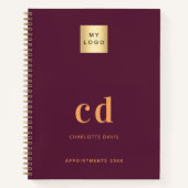 ワインレッドゴールドのモノグラムイニシャルビジネスロゴ ノートブック (正面)