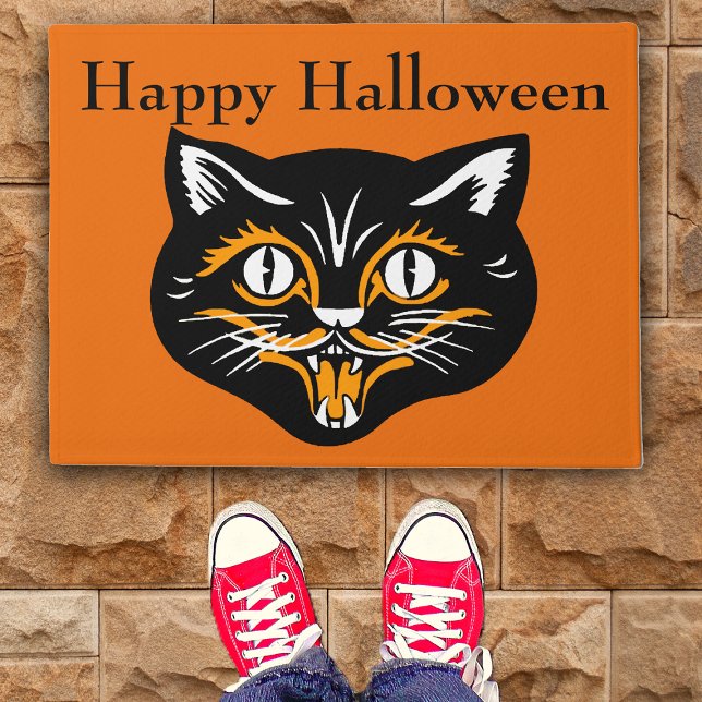 ヴィンテージクラシックハロウィーンブラックキャット顔ファン ドアマット (Vintage black cat Happy Halloween smiling face on orange door mat.)