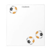 三つの黒オレンジ色のサッカーボールパーソナライズされた ノートパッド (正面)