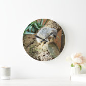 丸太の上に横になった眠そうなミーアキャット ラージ壁時計 (ホーム)