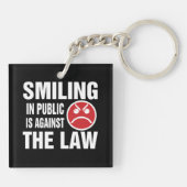 人前で微笑むのは法に反する キーホルダー (裏面)