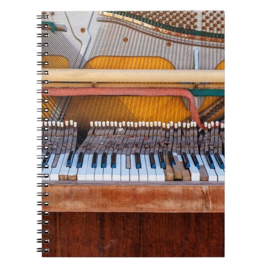 古いヴィンテージピアノの蓋を外した。荒れ果てた ノートブック (正面)