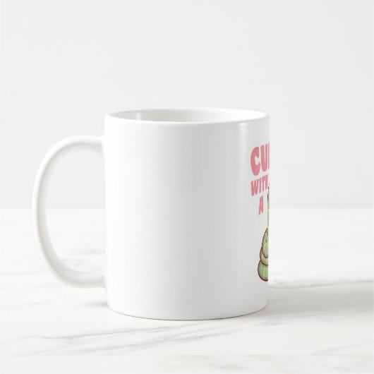 可愛い蛇が好きな本にくるまってます コーヒーマグカップ (左)