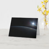 地球の地平線上に沈む太陽。 カード (黄色い花)