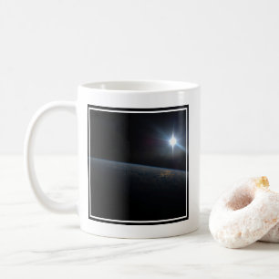 地球の地平線上に沈む太陽。 コーヒーマグカップ