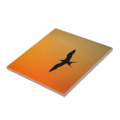 壮大なフリゲート飛んでいる鳥のオレンジ色の夕日 タイル (側面)