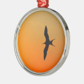 壮大なフリゲート飛んでいる鳥のオレンジ色の夕日 メタルオーナメント (左)