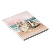 夕焼けでストライプのビーチに座る可愛い猫 ノートパッド (アングル)