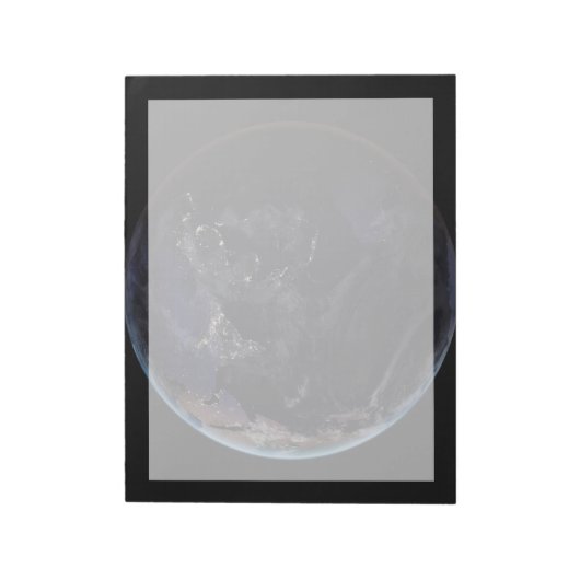 夜にアジアの都市の光を示す完全な地球。 ノートパッド (回転)