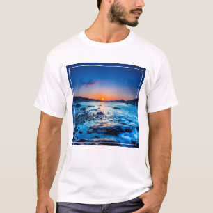 夜明けに海岸の地平線上の日の出 Tシャツ