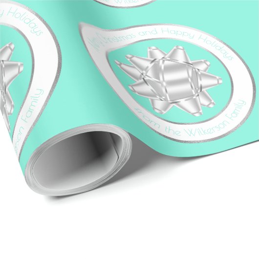 大きなシルバーのギフトボウが、ターコイズブルーの上に ラッピングペーパー (ロールコーナー)