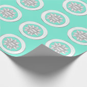 大きなシルバーのギフトボウが、ターコイズブルーの上に ラッピングペーパー (角)