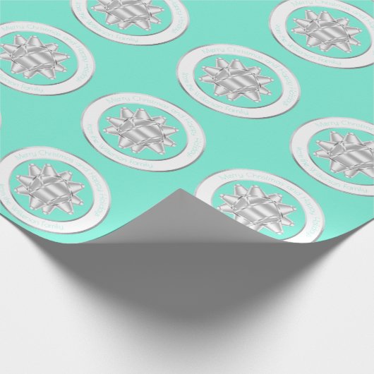 大きなシルバーのギフトボウが、ターコイズブルーの上に ラッピングペーパー (角)