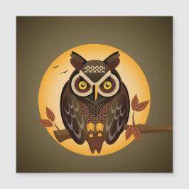 大きな目を月に向けて座っているフクロウ