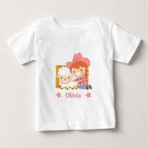 子羊を抱くかわいいカウガールの女の子用デザイン ベビーTシャツ