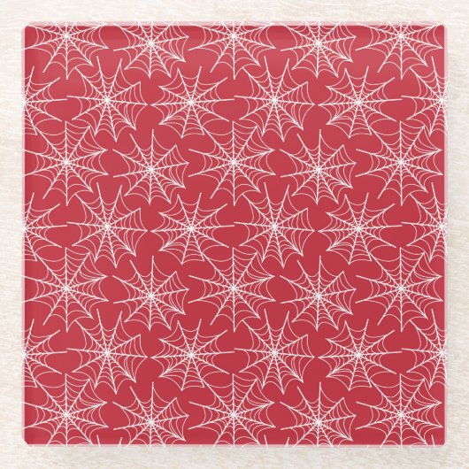 小さな白いハロウィーンのクモの巣が並んでいる赤 ガラスコースター (正面)