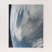 小さな衛星は地球の一部の上を公転する。 ジグソーパズル (縦)