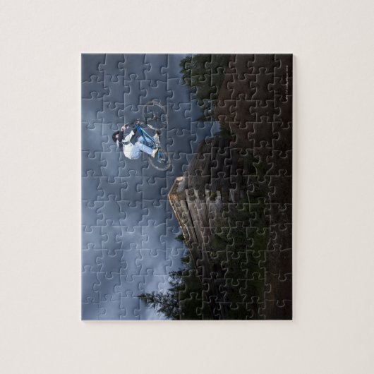 山のバイクもしくは自転車に乗る人がアイダホの丸太小屋から飛び降りる。 ジグソーパズル (縦)